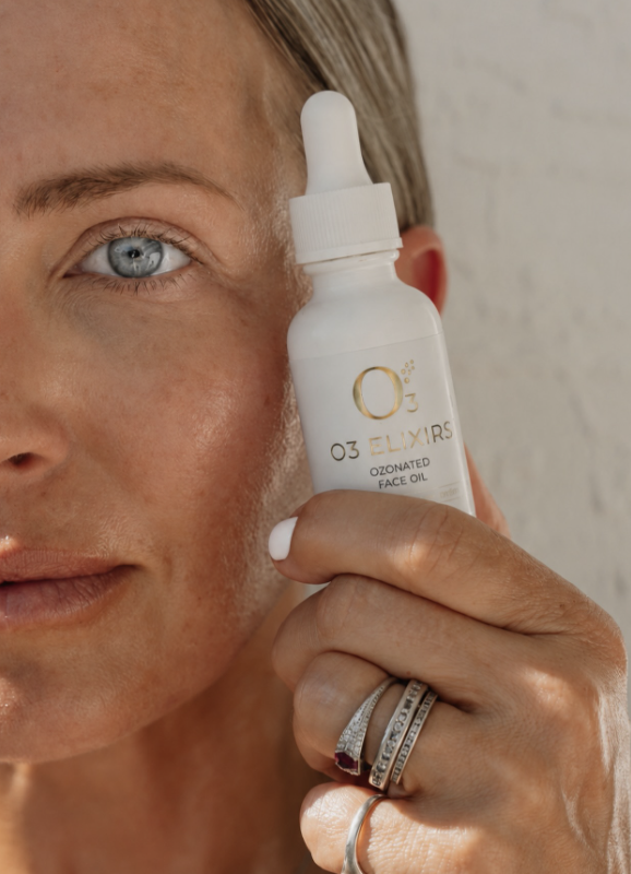Ashlee holding a bottle of O3 Elixirs face oil